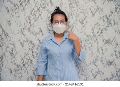 Woman Puts On A Face Mask Elegant  Wearing A Mouth Protection To Prevent Getting Sick At Work Or On The Way To Work  Isolated On White Background,pandemic And Social Distancing Concept.Covid-19