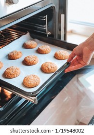 A Woman Puts In The Oven A Baking Tray With Oatmeal Cookies. Baking Process