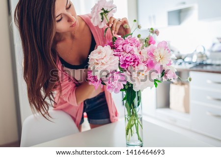 Similar – Woman with peonies on table in the living room