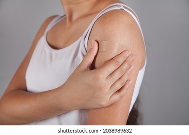 Woman Putting Adhesive Bandage On Arm.