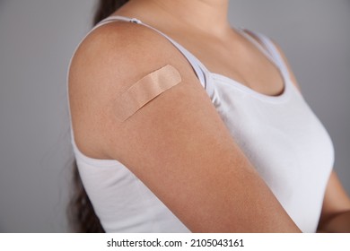 Woman Putting Adhesive Bandage On Arm.