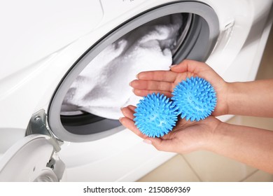 Woman Putting Blue Dryer Balls Into Washing Machine, Above View