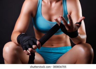 Woman putting boxing bandage on her hands - Powered by Shutterstock