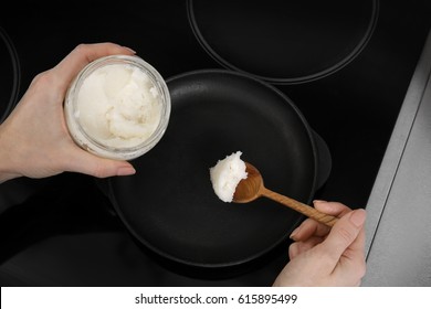 Woman Putting Coconut Oil Into Frying Pan