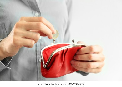 Woman Putting Coin Into Red Purse