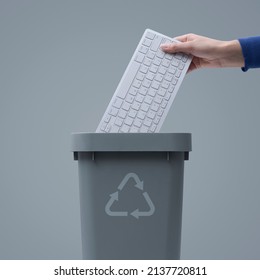 Woman Putting A Computer Keyboard In The E-waste Trash Bin, Recycling Concept