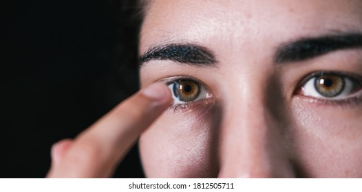Woman putting contact lens in her eye - Shutterstock ID 1812505711
