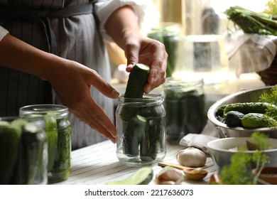 Woman Putting Cucumbers Into Jar In Kitchen, Closeup. Canning Vegetables