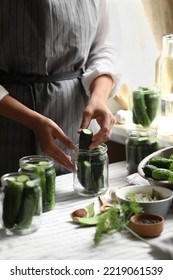 Woman Putting Cucumbers Into Jar In Kitchen, Closeup. Canning Vegetables