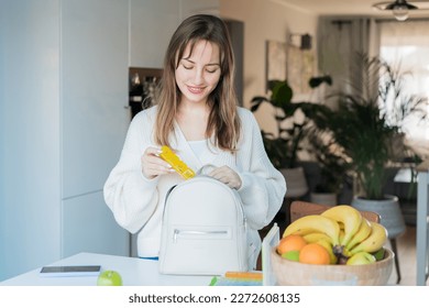Woman putting daily pills organizer into her bag. Taking daily medicine antioxidant diet vitamin supplements for beauty skin hair health care medicament biohacking concept. Selective focus. - Shutterstock ID 2272608135
