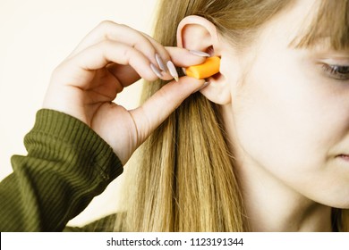 Woman Putting Ear Plugs Into Her Ears Getting Rid On Noise In Loud Place.