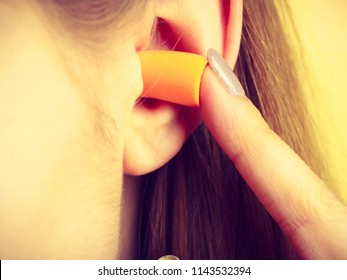 Woman Putting Ear Plugs Into Her Ears Getting Rid On Noise In Loud Place.