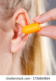 Woman Putting Ear Plugs Into Her Ears Getting Rid On Noise In Loud Place.