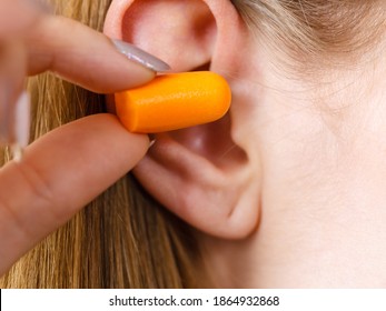 Woman Putting Ear Plugs Into Her Ears Getting Rid On Noise In Loud Place.