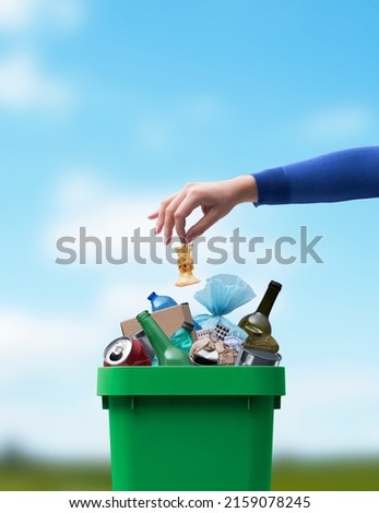 Woman putting food leftovers in a undifferentiated waste bin, improper waste management concept