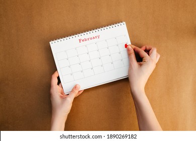 Woman Putting A Heart Sticker On A Calendar On Valentines Day.