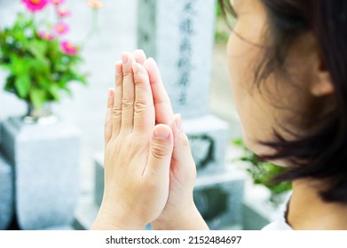 A woman putting her hands together to visit a grave, Japanese culture - Shutterstock ID 2152484697