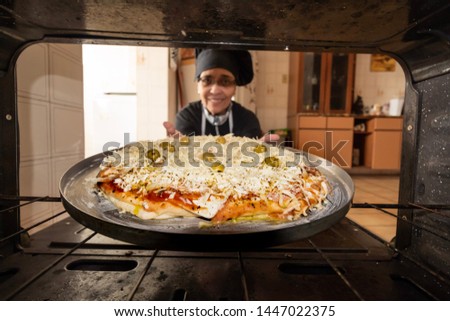 Woman putting a homemade pizza in the Oven