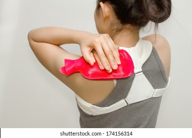 Woman Putting A Hot Pack On Her Shoulder Pain