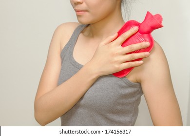 Woman Putting A Hot Pack On Her Shoulder Pain