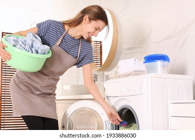 Woman putting laundry detergent capsule into washing machine indoors - Shutterstock ID 1933886030