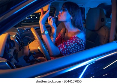 Woman Putting Lip Gloss On Her Lips In Car