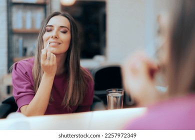
Woman Putting Lip-gloss on in the Mirror. Relaxed girl getting ready applying make-up 
 - Shutterstock ID 2257972349
