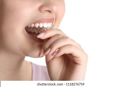 Woman Putting Occlusal Splint In Mouth On White Background, Closeup