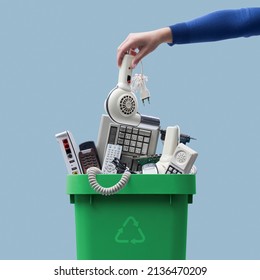 Woman putting an old broken appliance in the trash bin, e-waste and recycling concept - Shutterstock ID 2136470209