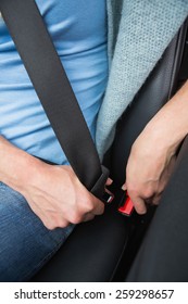 Woman Putting On Her Seat Belt In Her Car