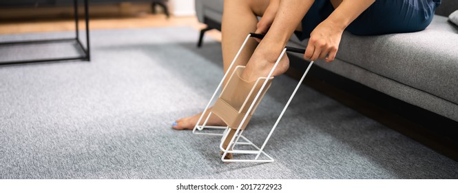 Woman Putting On Medical Compression Stockings Using Stocking Aid Puller