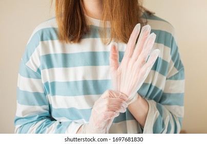 Woman Putting On Transparent Vinyl Gloves