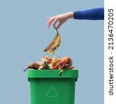 Woman putting organic biodegradable waste in a recycling bin, separate waste collection concept