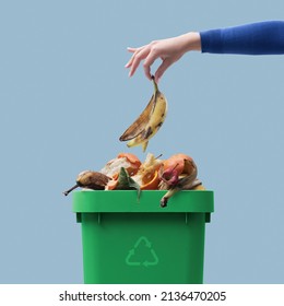 Woman putting organic biodegradable waste in a recycling bin, separate waste collection concept - Shutterstock ID 2136470205