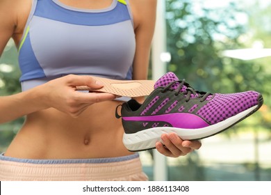 Woman Putting Orthopedic Insole Into Shoe Indoors, Closeup. Foot Care