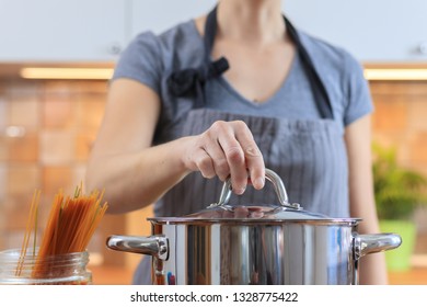 Woman Putting Pasta In Boiling Water