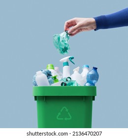 Woman putting a plastic bottle in a full recycling bin, separate waste collection concept - Shutterstock ID 2136470207