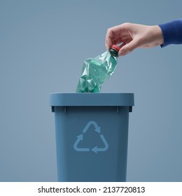 Woman putting a plastic bottle in a trash bin, waste sorting and recycling concept - Powered by Shutterstock