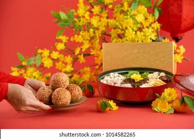 Woman Putting Plate With Dried Rice Balls On Table Served For Tet Celebration