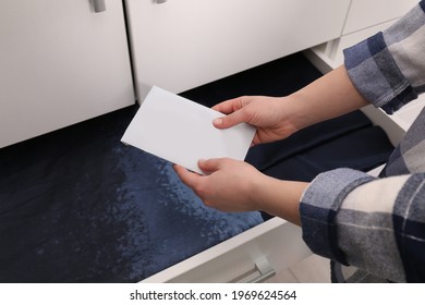 Woman putting scented sachet into drawer with linens, closeup