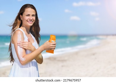 Woman Putting Sunblock Lotion Before Tanning During Summer Holiday On Beach. Sun Cream. Skin Care. Sun Protection