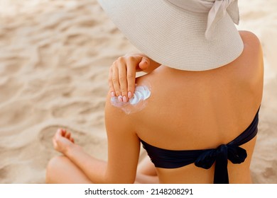 Woman putting sunblock lotion on shoulder before tanning during summer holiday on beach. Sun cream. Suntan.  Beautiful Woman Applying  Sunscreen Solar Cream. Skin care. Sun protection - Shutterstock ID 2148208291