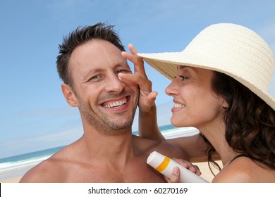 Woman Putting Sunblock On Her Boyfriend's Nose