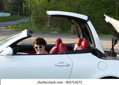 Woman Putting the Top Down on a Hardtop Convertible Sports Car