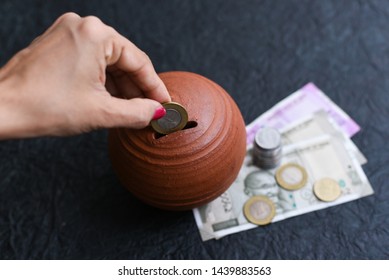 Woman Putting Wages In Coin Stack Jar Saving Money For Her Child. Kids Piggy Bank For Savings Cash Deposit For Future. 500 Rupee Banknote India. Profit From Business. New Indian Currency Notes Of 2000