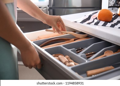 Woman Putting Wooden Spoon Into Kitchen Drawer