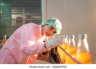 Woman Quality Control a fruit drink factory in glass bottles Inspecting glass bottle packaging for fruit juice drinks, Worker QC working in a drink water factory. - Shutterstock ID 2206567025