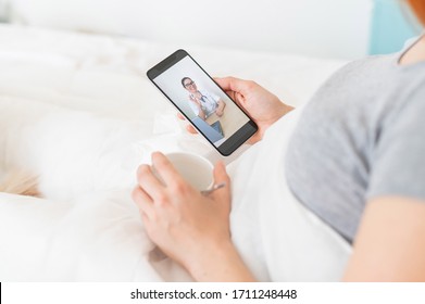 A Woman Is Quarantined At Home And Is Conducting A Video Conference With A Virologist. The Patient Lies On The Bed With A Phone In Her Hands. Call From The Doctor.