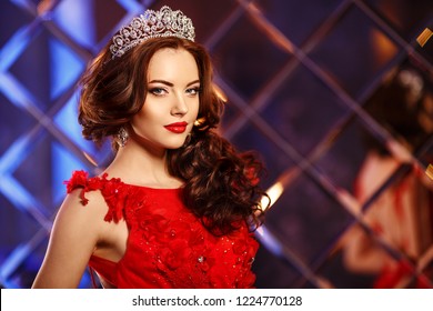 Woman queen princess in crown and  dress, lights party background Luxury girl Long shiny healthy volume hair Waves Curls Hairstyle Salon Fashion model luxurious vintage interior Jewelry