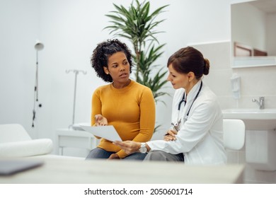Woman questioning doctor about medical test result. Doctor and patient talking at medical office.